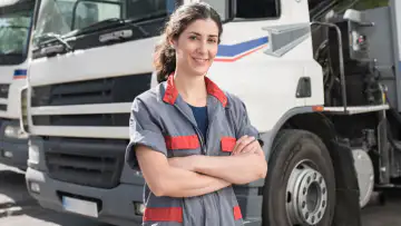 Truck driver stands in front of their vehicle