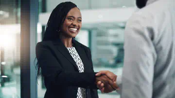 Businesswoman shakes hands with a colleague