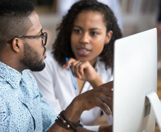 Coworkers discussing documents on the computer